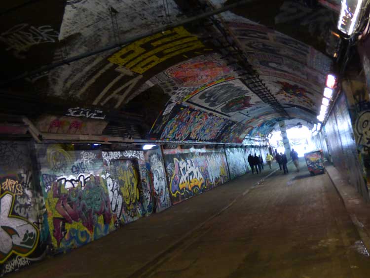 Graffiti-covered tunnel with harsh lighting